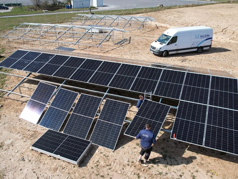 Malvetra komanda montuoja antžeminę saulės elektrinę, šalia įmonės furgonas